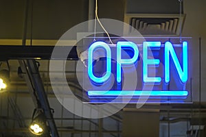 Neon light color blue Open sign on a glass window for business front of shop
