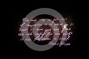 Neon light of a quote from Oscar Wilde about temptation