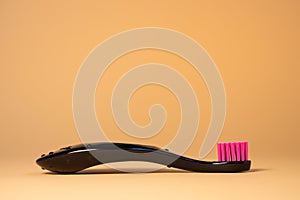 Neon pink plastic baby tooth brush on natural background. Dental and healthcare concept.