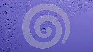 Neon purple background of wet glass with dripping droplets and copy space