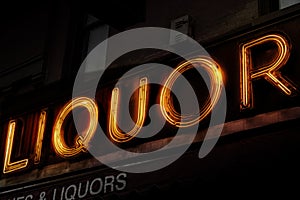 Neon sign liquor and spirts store front at night lighted sign