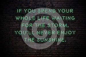 Neon sign with wise quote on brick wall in the darkness