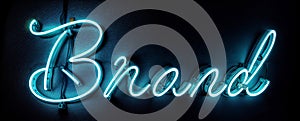 A neon sign word text Brand in cursive, glowing blue against a black background