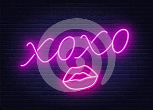 Neon sign xoxo with a kiss on a dark background. photo