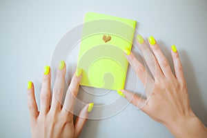 Neon yellow trendy female manicure. Nail polish.