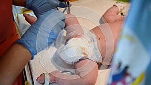 Neonatal resuscitation. Female doctor examining newborn baby in clinic