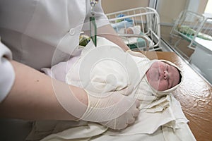 Neonatology. A newborn in a special incubator. medical staff