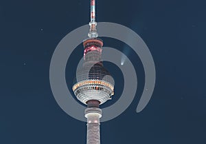 Neowise Comet visible in city of Berlin over TV tower with illuminated night sky. Astro photo during night time with