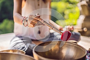 Nepal Buddha copper singing bowl at spa salon. Young beautiful woman doing massage therapy singing bowls in the Spa