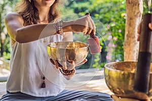 Nepal Buddha copper singing bowl at spa salon. Young beautiful woman doing massage therapy singing bowls in the Spa