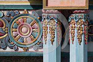 Nepal, Tibetan buddhist ornamented pillars and Chackra wheel in the background.