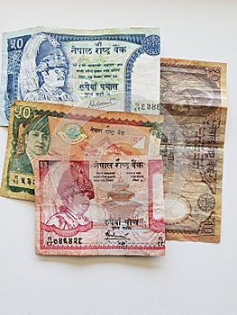 Nepalese banknotes of different denominations on the white table
