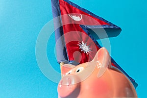 The Nepalese flag and a piggy bank are a symbol of profitable investments or economical purchases.