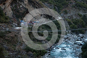 Nepalese mountain village by a suspension bridge over the Marshyangdi river