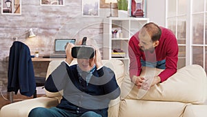 Nephew teaching his grandfather how to use virtual reality headset