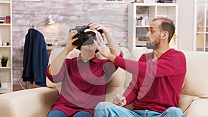 Nephew teaching his grandmother how to use virtual reality headset