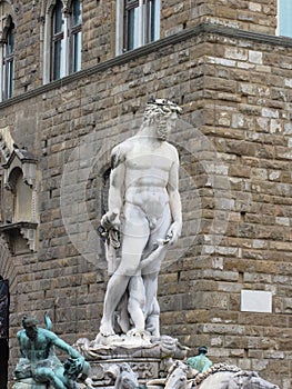 The Neptune fountain and Palazzo Vecchio in Florence, Italy . Detail of the Neptune statue .