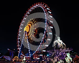 Neptune god statue looking at the shiny ferris wheel in Berlin photo