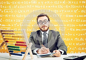 Nerd accountant does calculation of company revenue on yellow background