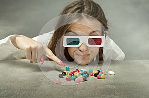 Nerd girl with 3d glasses indicated candy photo