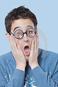 Nerd man wearing novelty glasses with mouth open in surprise over blue background