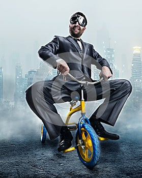 Nerdy businessman riding a small bicycle