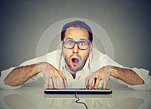 Nerdy looking man in glasses typing on keyboard