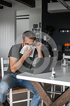 Nerdy man with glasses freelance working from home during the covid pandemic or flu