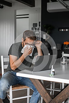 Nerdy man with glasses freelance working from home during the covid pandemic or flu