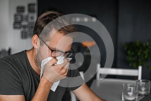 Nerdy man with glasses freelance working from home during the covid pandemic or flu