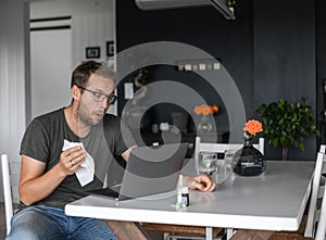 Nerdy man with glasses freelance working from home during the covid pandemic or flu