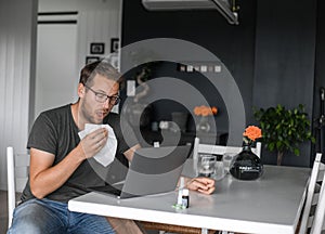 Nerdy man with glasses freelance working from home during the covid pandemic or flu