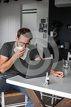 Nerdy man with glasses freelance working from home during the covid pandemic or flu