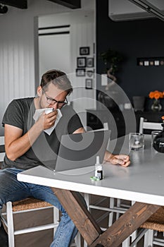 Nerdy man with glasses freelance working from home during the covid pandemic or flu