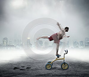 Nerdy man standing on a small bicycle