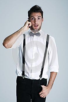 Nerdy young man in suspenders on the phone