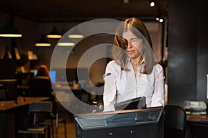 Nervous breakdown at work. Business woman freaks out and breaks the computer in the office photo