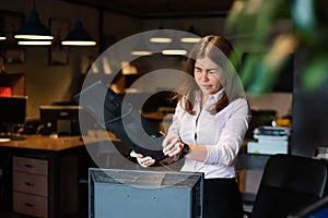 Nervous breakdown at work. Business woman freaks out and breaks the computer in the office