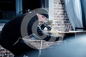 Nervous burglar looking for documents in the table