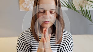 Nervous confusion. Terrified panic. Scared and worried dark haired woman wearing striped shirt sitting indoor at home having