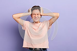 Nervous emotional young woman with closed eyes touching temples