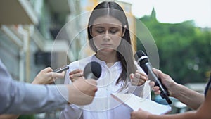 Nervous female celebrity talking with annoyed journalists searching for scandal