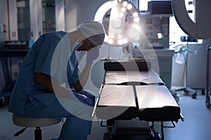 Nervous female surgeon sitting in operation room at hospital