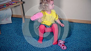 Nervous girl playing with her shoes. Child cant put sandal on