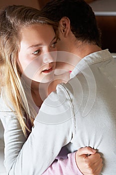 Nervous Looking Teenage Girl Sitting On Sofa