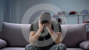 Nervous male military suffering depression, sitting alone at home, PTSD concept