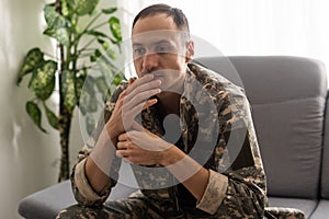 Nervous male military suffering depression, sitting alone at home, PTSD concept