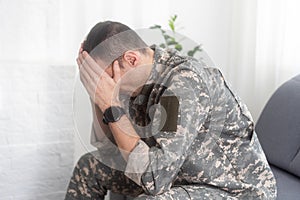 Nervous male military suffering depression, sitting alone at home, PTSD concept