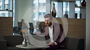 Nervous man talking videocall confused by mistake using laptop at work office