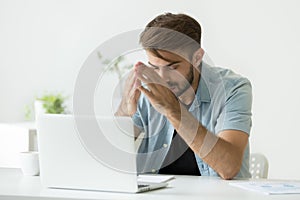 Nervous man thinking over problem trying to focus at work